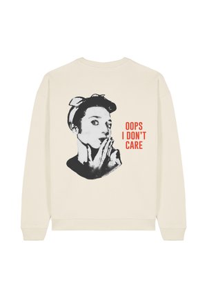 Felpa color crema con una grafica in bianco e nero di una donna con un fiocco, accompagnata da un testo rosso in grassetto che dice "OOPS NON MI INTERESSA."