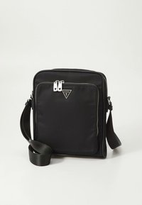 Mala preta retangular de tiracolo com bolso frontal com fecho de correr, puxadores prateados, alça ajustável e logótipo triangular da Guess na parte da frente.