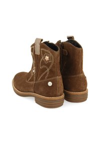 Stivali ankle in suede marrone con cerniere laterali, cuciture decorative, accenti a stella e una robusta suola in gomma. Presenta un logo metallico con marchio.