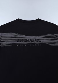 T-shirt noir avec une bande graphique texturée grise au dos, avec "NAPAPIJRI" et "geographic" imprimés en blanc. Coupe standard.