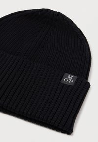 Crni pleteni beanie s rebrastom teksturom, s preklopnim rubom i malom oznakom brenda u sivoj boji na prednjoj strani.