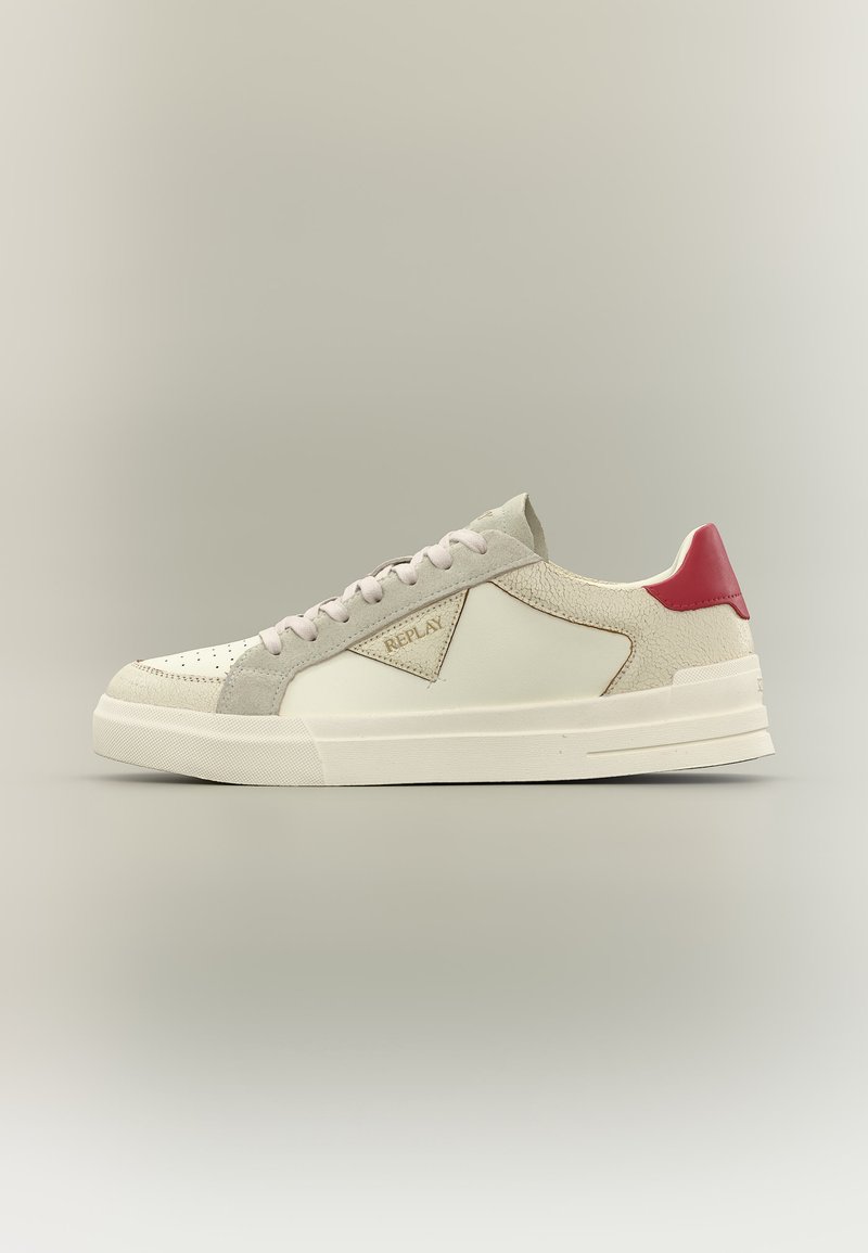 Basket basse beige et blanche avec un patch rouge au talon, lacets à l’avant et un panneau latéral texturé avec le logo Replay.