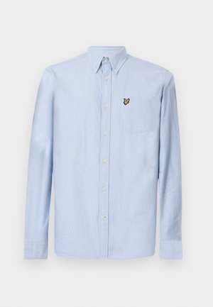 Lyseblå langermet skjorte med knappekrage, frontlomme og brodert logo. Laget av strukturert bomullsstoff.