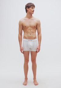 Boxers en coton blanc avec une coupe ajustée, une ceinture douce avec des accents multicolores et une texture lisse.