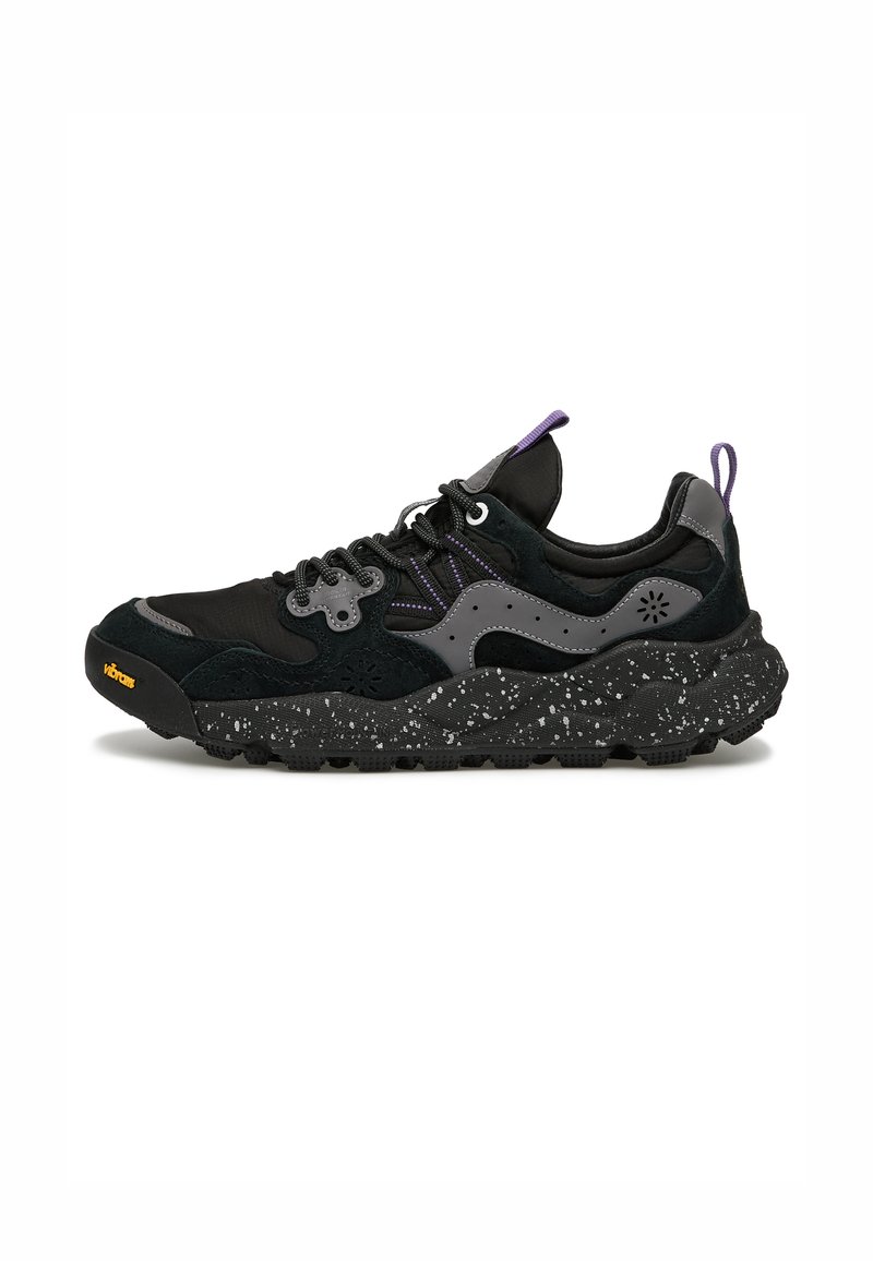 Scarpe sportive nere e grigie con una suola testurizzata e maculata, tomaia in tessuto e accenti viola. Presentano una punta rinforzata e un design con lacci.