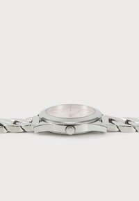 Silver wristwatch with a polished stainless steel band, round case, pink dial, and hour markers. Features a crown on the side.
