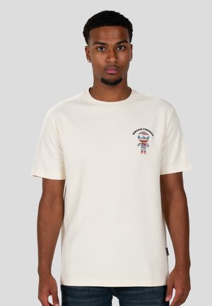 Camiseta de algodón crema con mangas cortas, que presenta un colorido gráfico bordado de "Wrong Friends" en la parte izquierda del pecho.