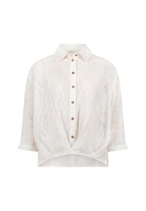 Blouse semi-transparente beige clair avec un col, des boutons marron sur le devant, des manches trois-quarts et un détail noué torsadé à l'ourlet.