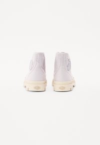 High-top sneakers in light lavender canvas with textured fabric, white rubber soles, and a circular logo on the outer heel.