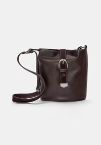 Braune Leder-Eimer-Tasche mit runder Form, silbernen Hardware-Details, verstellbarem Tragegurt und genähten Akzenten am Verschluss.
