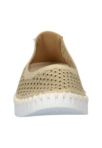 Beige instapschoenen met een geperforeerde bovenkant en een witte structuurzool. Vlechtaccent rond de zool. Eenvoudig, afgerond ontwerp.