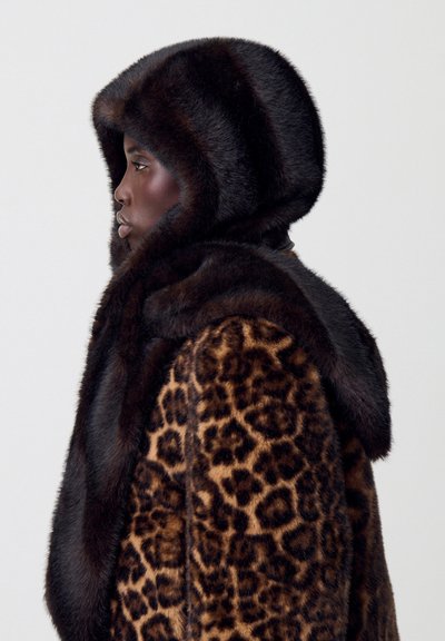 Cappotto di pelliccia con stampa leopardata e cappuccio in pelliccia scura abbinato. Il cappotto presenta una texture morbida e un design aderente, accentuato dal volume del cappuccio.