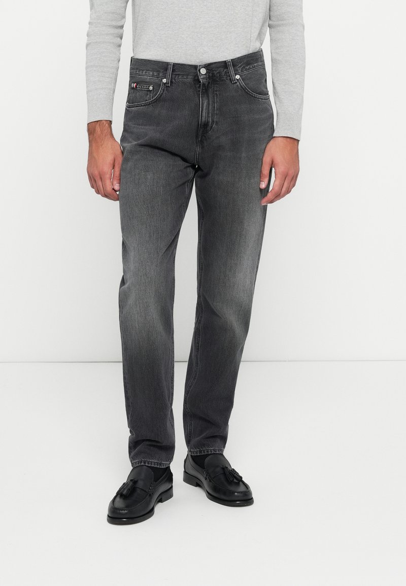 Jeans de denim cinza com um corte regular, design de cinco bolsos e costura em contraste. Combinados com mocassins pretos para um look polido.