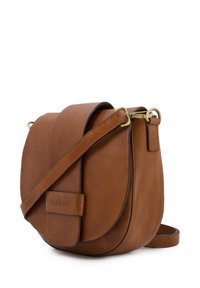 Brun læder crossbody taske med en buet form, guld hardware og en magnetisk klaplukning. Har en aftagelig skulderrem.
