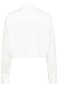 Krótkia biała koszula wykonana z gładkiej tkaniny. Posiada kołnierzyk z wycięciem oraz długie rękawy z mankietami zapinanymi na guziki. Prosty design, bez widocznych wzorów.