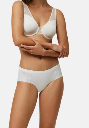 Sostén blanco con diseño de malla transparente y tirantes ajustables, combinado con bragas tipo hipster blancas a juego con cintura ondulada.