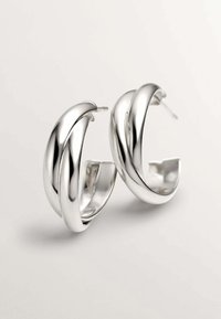 Pendientes de aro de plata con un diseño retorcido, que presentan una superficie brillante y suave, y un cierre a presión.