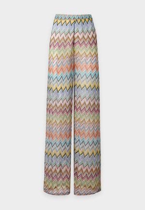 Bukser med brede ben med et farverigt zigzag-mønster i nuancer af grøn, blå, orange, gul og lilla på en lys baggrund.