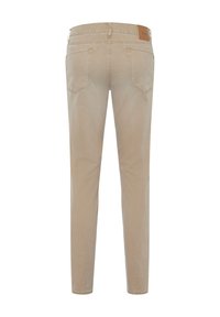 Pantalon en denim beige à coupe slim, doté de cinq poches, d'une étiquette en cuir à la taille et de coutures surpiquées. Texture lisse et design minimaliste.