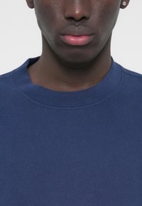 Μπλε ναυτικό φούτερ με στρογγυλή λαιμόκοψη, ραμμένο με ριμπ ύφασμα στη λαιμόκοψη, έχει λείο υλικό και ελάχιστες ραφές στους ώμους.