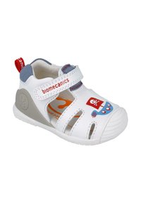 Sandalia blanca con una correa de Velcro, acentos azules y gráficos de temática pirata. Fabricada con material duradero, cuenta con ranuras de ventilación y una punta protectora.