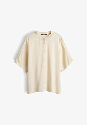 Kurzärmeliges Hemd in Cremefarben mit rundem Kragen und Knopfleiste vorne, flach liegend auf weißem Hintergrund dargestellt.