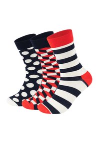 Trois paires de chaussettes en coton : bleu marine à pois blancs, rouge à motifs géométriques, et rayures bleu marine/blanc avec des accents rouges.
