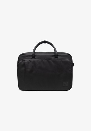 Bolsa de portátil negra con forma rectangular, textura de tela suave, dos asas en la parte superior y un bolsillo con cremallera en la parte frontal. Presenta un parche con el logo de la marca.