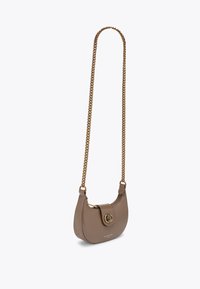 Borsa in pelle marrone con forma curva, tracolla in catena dorata e chiusura decorativa. Texture liscia con zip e dettaglio del logo.