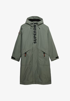 Lange olijfgroene mantel met capuchon, voorzakken, zwarte tekst "SUPERDRY" op de ritsflap en een logopatch op de linker mouw.