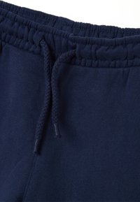 Marineblaue Jogginghosen mit geripptem Bund und Kordelzug. Weicher Stoff, minimale Nähdetails und lässiges Design.