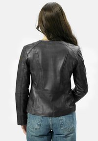 Schwarze Lederjacke mit figurnaher Passform, sichtbaren Nähten und glatter Textur. Die Rückansicht zeigt maßgeschneiderte Nähte und eine klassische Silhouette.