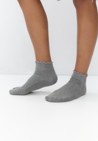 Gray ribbed ankle socks with a scalloped edge detail, made of soft material, featuring a textured pattern.