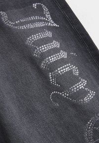 Μαύρο ύφασμα από τζιν με λαμπερό σχέδιο αποτελούμενο από μικρές στρας που σχηματίζουν κυματιστά μοτίβα. Η υφή είναι λεία και casual.