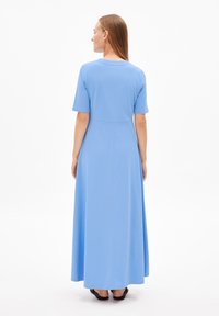 Robe bleu clair, longueur cheville, avec des manches courtes, un col rond et une couture de taille ajustée. Texture lisse avec un minimum de détails.