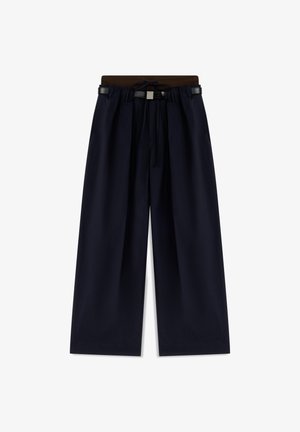 Weit geschnittene marineblaue Hose mit braunem elastischem Bund und schwarzem Gürtel, vordere Falten und Kordelzug-Detail.