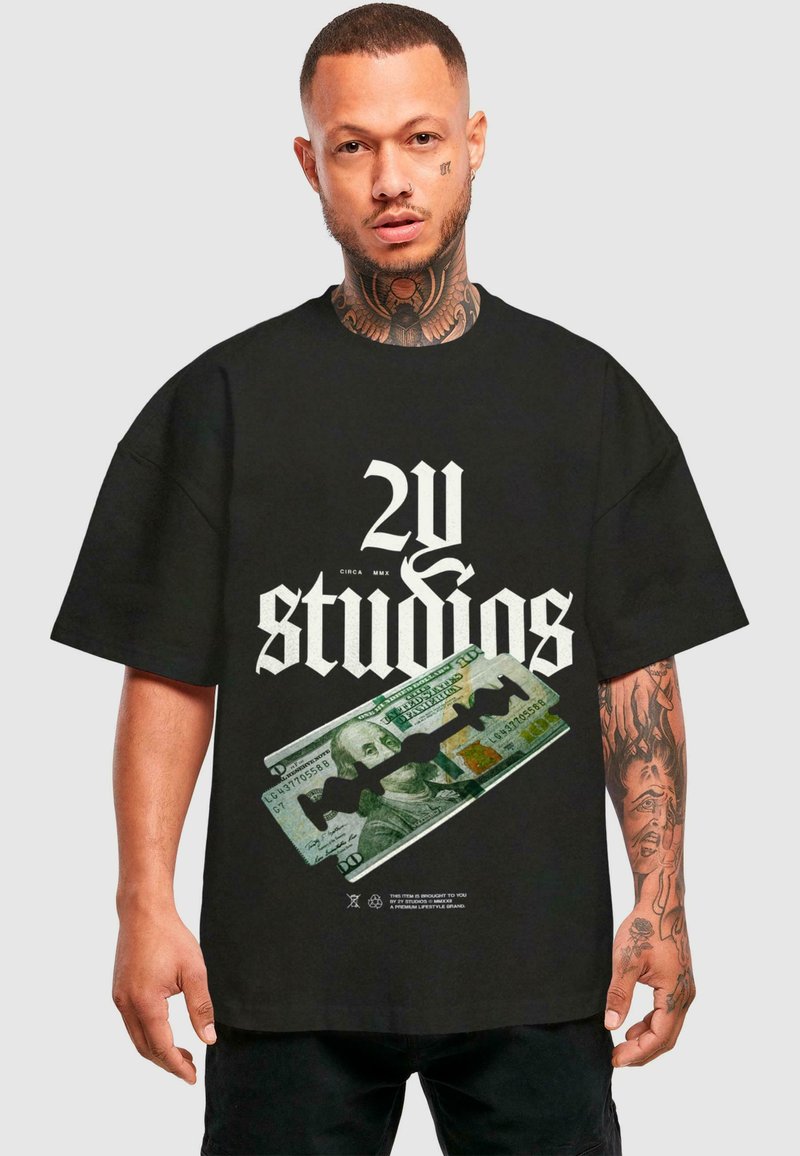 Melna pārslēgta t-krekls ar izteiksmīgu balto tekstu "2U studios" un grafiku, kurā attēlots simts dolāru rēķins ar skalpeli.