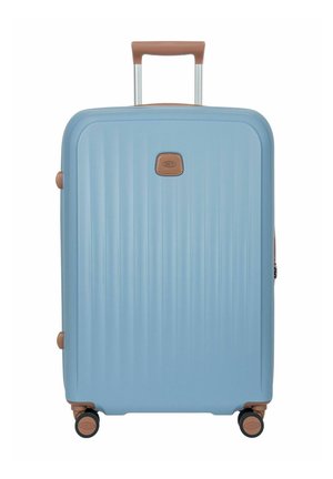 Valise rigide bleu clair avec poignées marron, quatre roulettes pivotantes et une poignée télescopique rétractable.