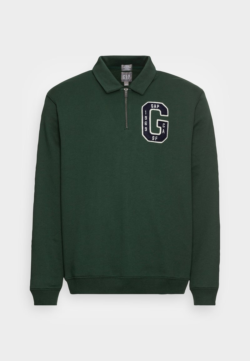 Pull vert foncé à manches longues avec col, demi-fermeture éclair et écusson noir et blanc "GAP 1969 CA SF" sur la poitrine gauche.