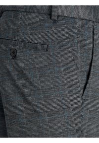 Tissu à carreaux gris avec de fines lignes bleues formant un motif à carreaux sur un pantalon sur mesure avec une poche arrière à bouton.