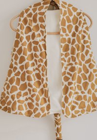 Šalle ar žirafes rakstu brūnu toņu toņos uz krēmkrāsas fona, ar aizdares auklu un gludu, vieglu audumu.