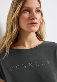 Dark gray, short-sleeve shirt with a round neckline featuring the word "CONNECT" in crystal bead embellishment on the front.
