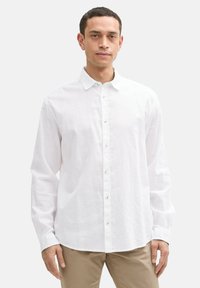 Witte linnen blouse met een knoop-onder-collier, lange mouwen en knoopsluiting aan de voorkant. Heeft een gladde textuur en een relaxte pasvorm.