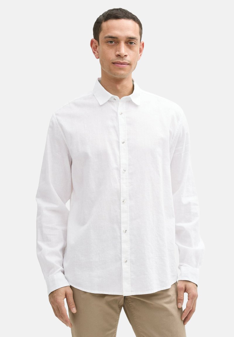 Witte linnen blouse met een knoop-onder-collier, lange mouwen en knoopsluiting aan de voorkant. Heeft een gladde textuur en een relaxte pasvorm.