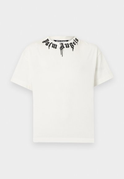 Λευκό βαμβακερό μπλουζάκι με στρογγυλή λαιμόκοψη που διαθέτει μαύρο κεντητό κείμενο κατά μήκος της λαιμόκοψης. Κοντά μανίκια και άνετη εφαρμογή.