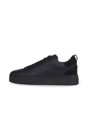 Zwarte lage leren sneaker met een gestructureerd oppervlak, dikke zool, veters aan de voorkant en een klein rechthoekig logo-label aan de zijkant.