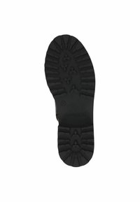 Suela de goma negra con una superficie texturizada que presenta profundas ranuras y un patrón en forma de diamante para mayor tracción. Marcada con el tamaño y el logotipo de la marca.