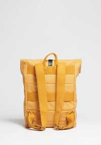 Zaino in tessuto giallo con una finitura testurizzata, design imbottito, spallacci regolabili e una maniglia superiore per un trasporto facile.