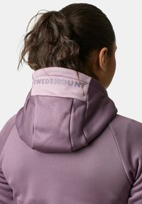 Paarse hoodie met een contrasterende lichtpaarse kraag, met het woord "SWEDEMOUNT" in het grijs op de achterkant gedrukt. Glad, rekbaar materiaal.