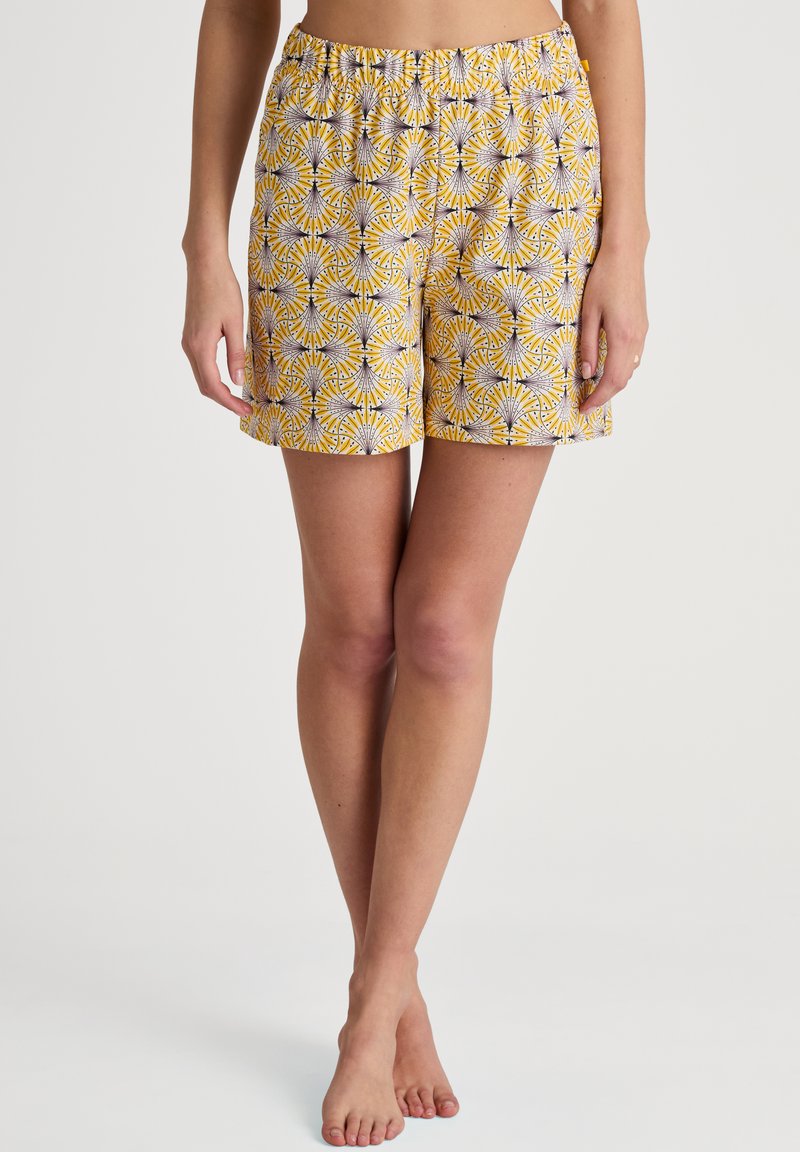 Geel gekleurde shorts met een bloemenpatroon, elastische tailleband en een ruime pasvorm. Het materiaal lijkt lichtgewicht en comfortabel te zijn.